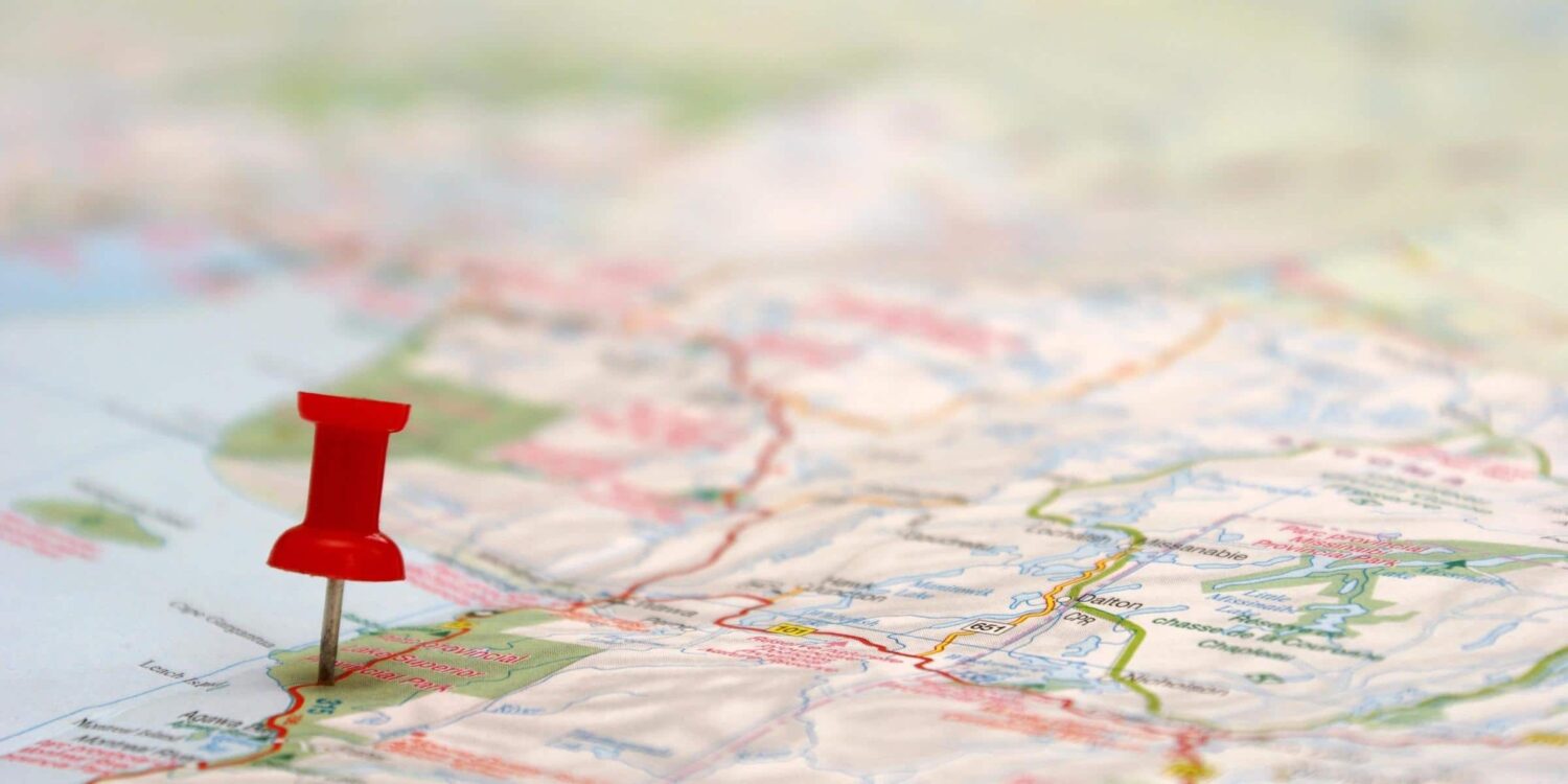 A red pin is placed in a paper map.