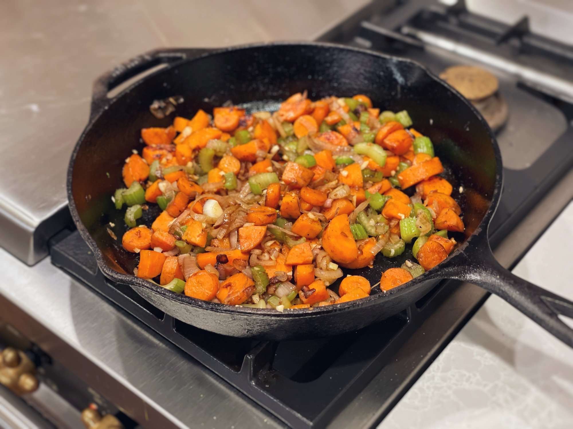 Sautéing carrots, onion and celery in a cast iron skillet on a gas range