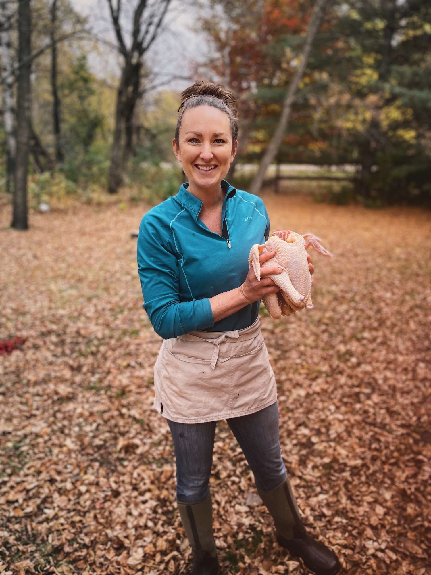 Katie holding a red ranger chicken outside in the fall