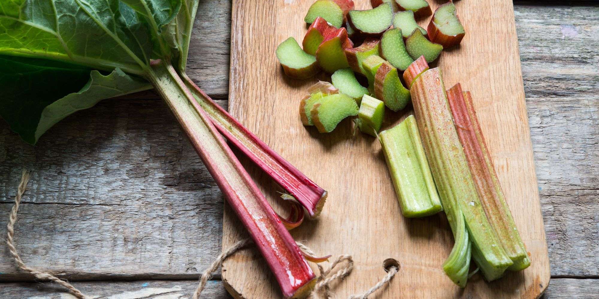 Rhubarb stalk being chopped on a wooden cuttingboard