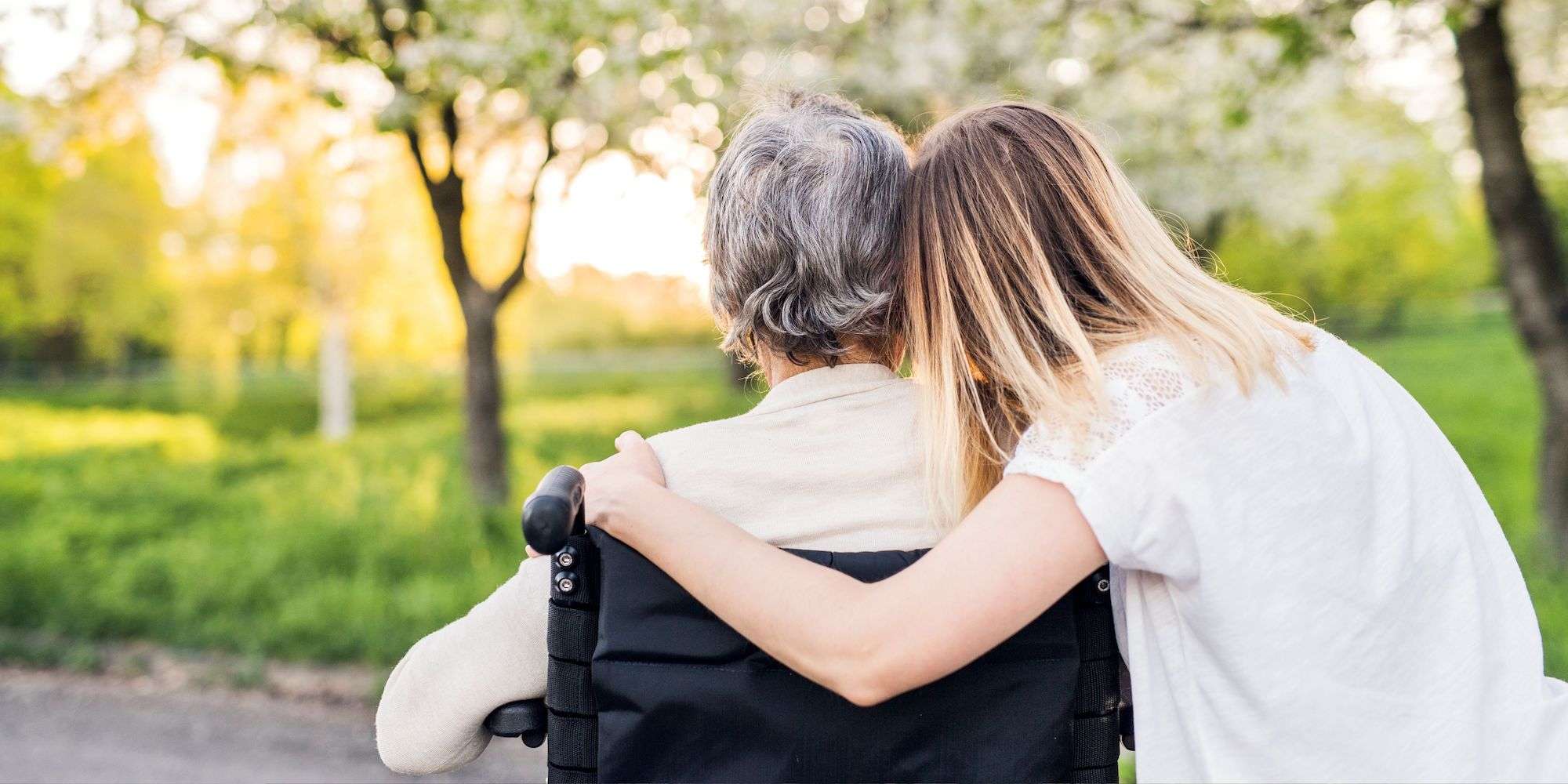 Woman in wheelchair being embraced by granddaughter