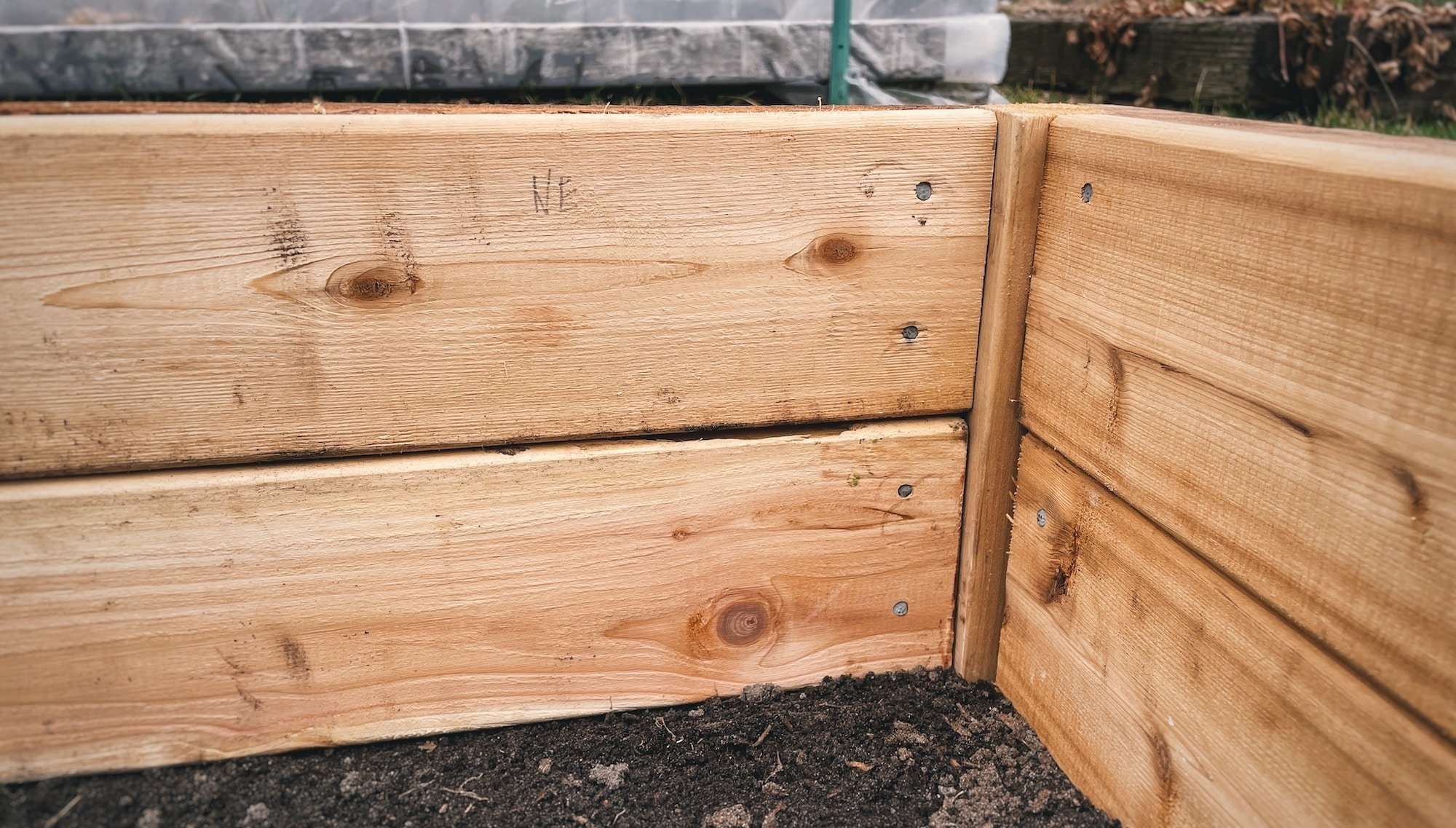 Cedar decking planks nailed into the frame of a raised bed