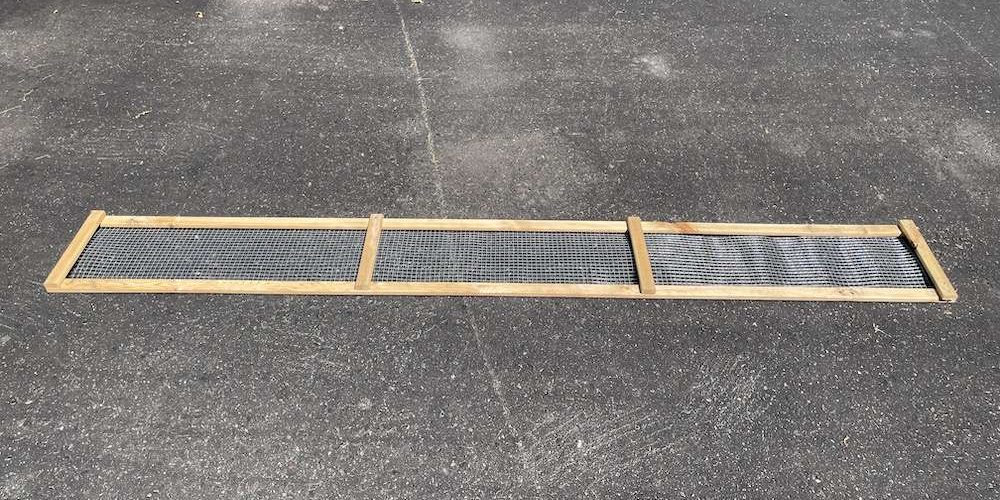 A no-dig skirt built with frame and hardware mesh laying on the driveway