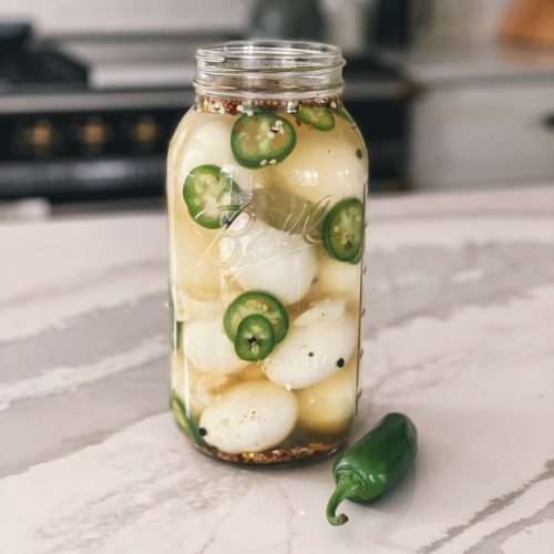 A half gallon mason jar filled with jalapeno pickled eggs