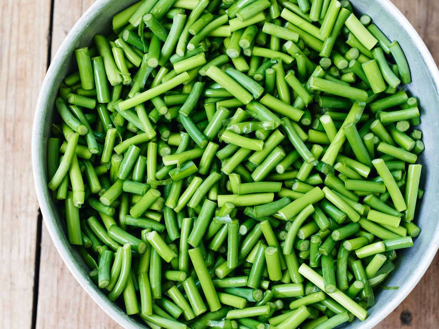 A photo of chopped garlic scapes in a bowl