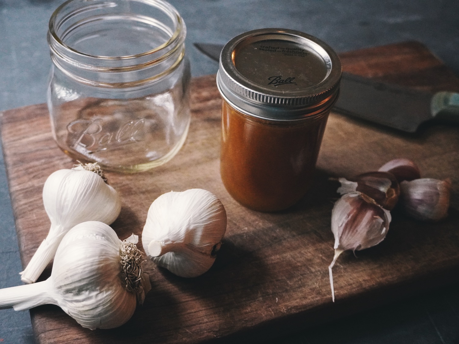 Ingredients for making fermented honey garlic spread out on a wooden cutting board