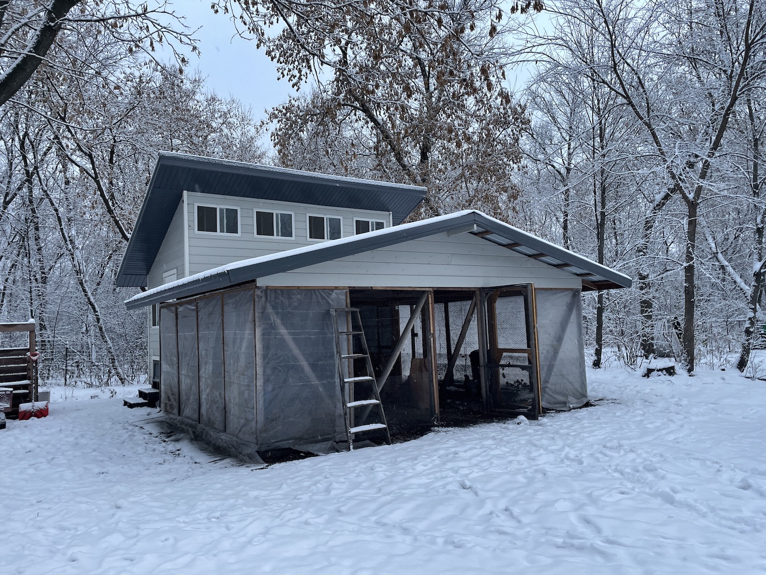 A large chicken coop in the winter with snow