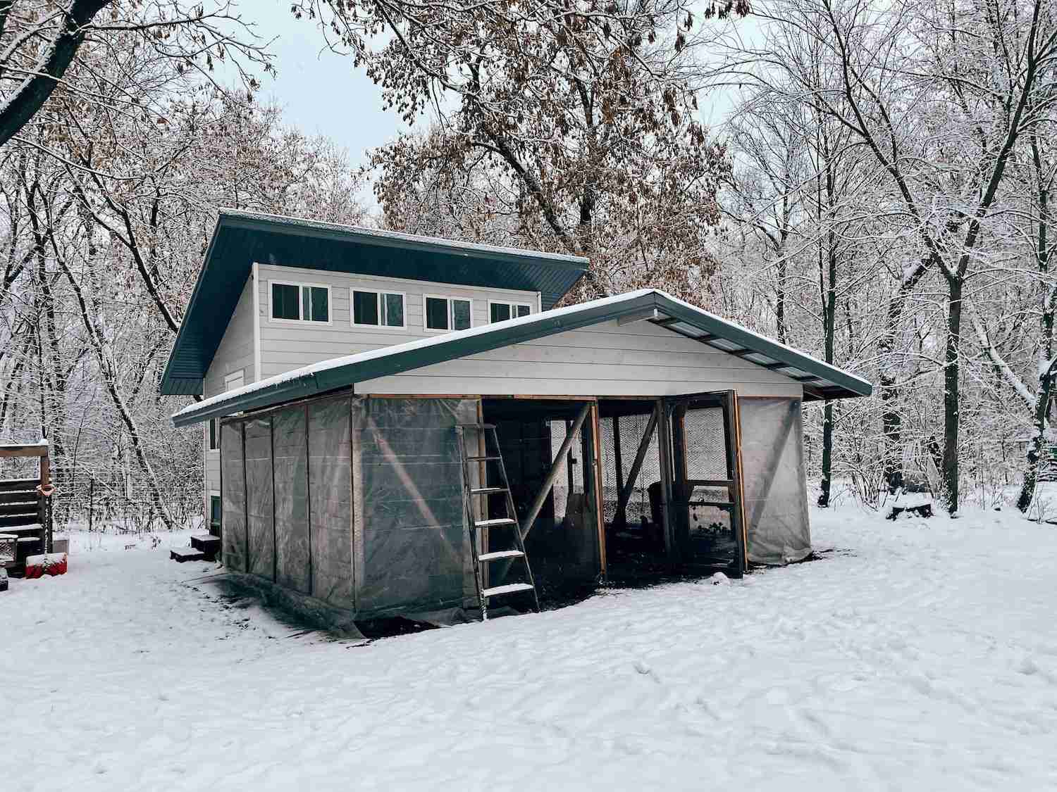 A photo of a winterized chicken coop with lots of snow