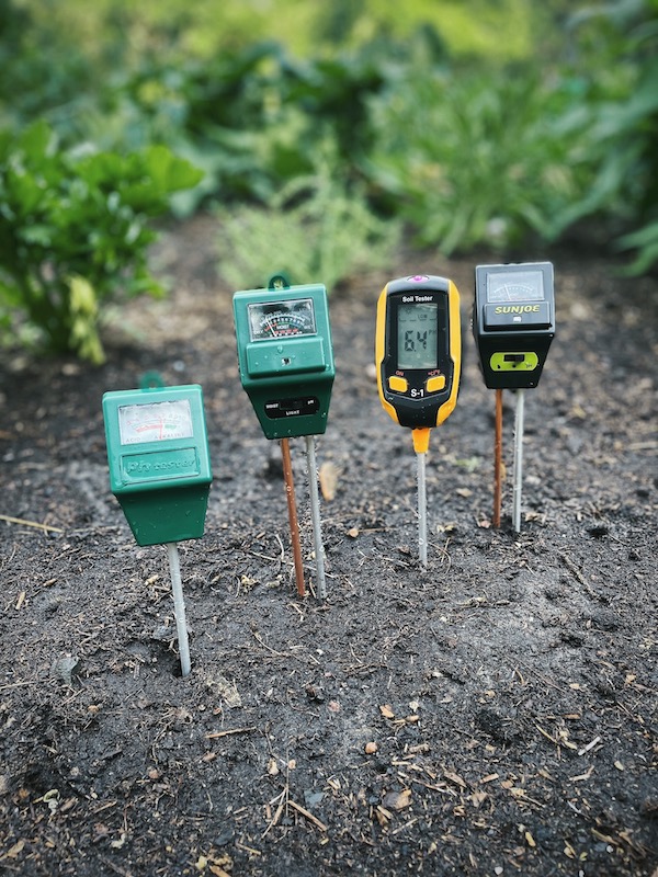 Soil pH testers set up in the garden next to each other