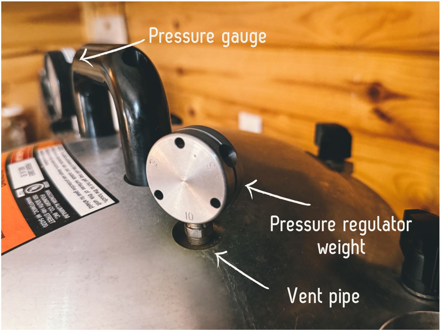 A photo showing how to add the pressure regulator weight to a pressure canner. Also labels for each part.