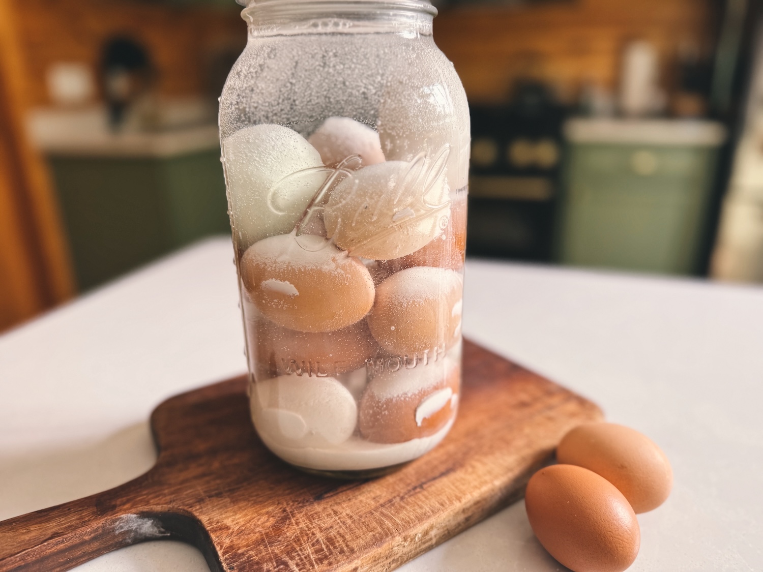 A close up shot of water glassed eggs in a half gallon glass jar